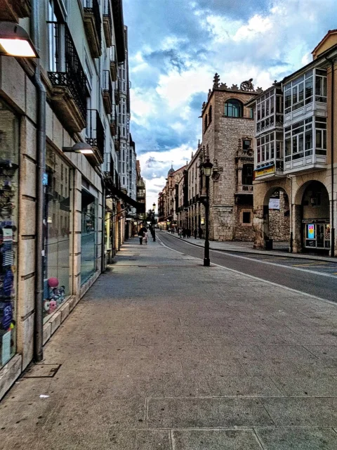 La calle Santander al atardecer, con los soportales de piedra a la derecha y la acera ancha