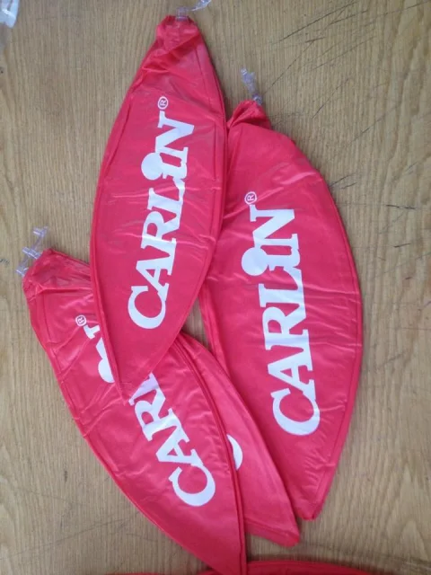 Fundas rojas de tela con el logotipo blanco de Carlin sobre una mesa de madera