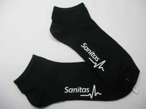 Par de calcetines tobilleros negros personalizados con el logotipo blanco de Sanitas
